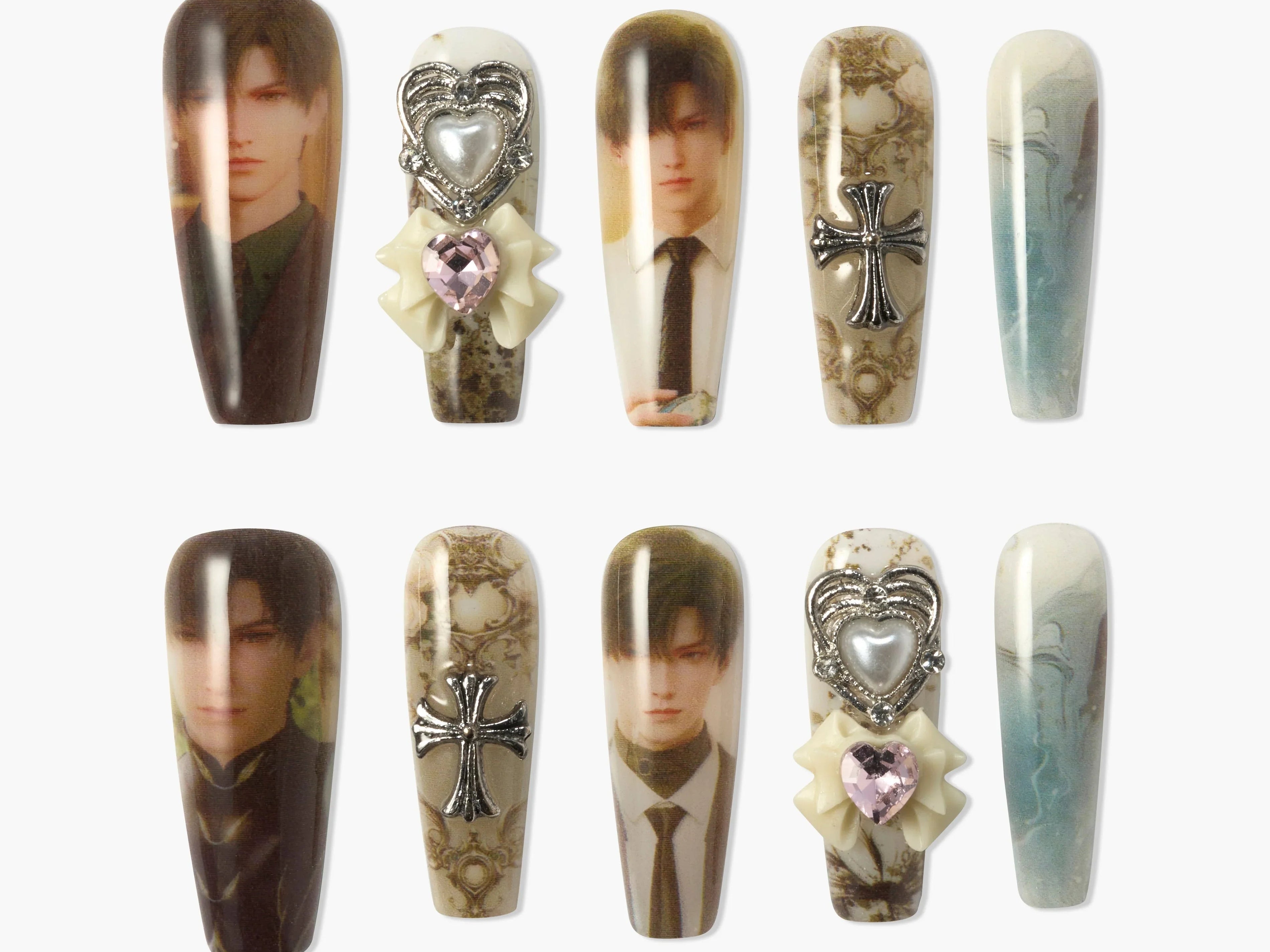 Set of decorative press-on nails featuring male portrait art, intricate cross charms, and gemstone accents
