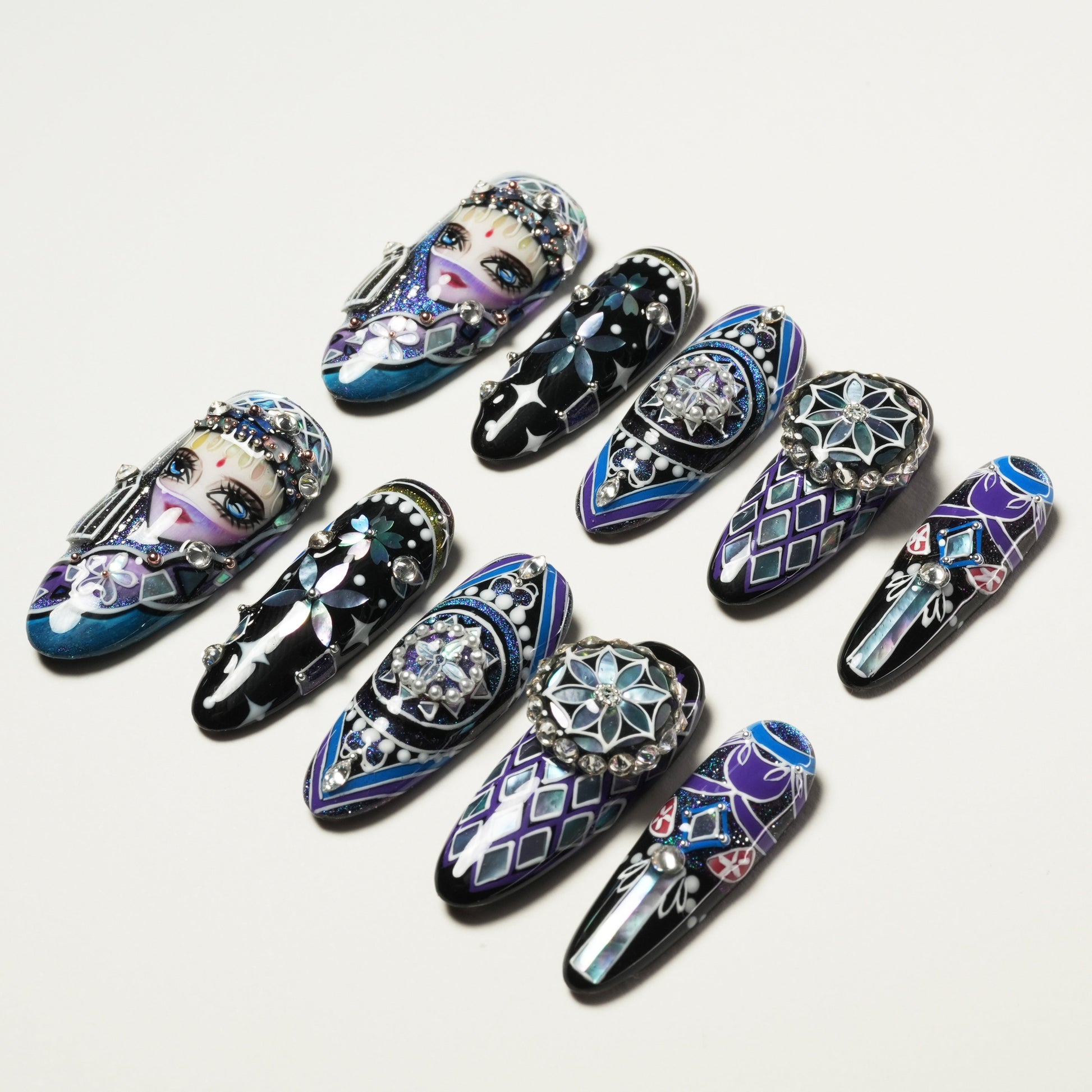 Set of ten intricately designed, jeweled and hand-painted long fake nails with faces and geometric patterns