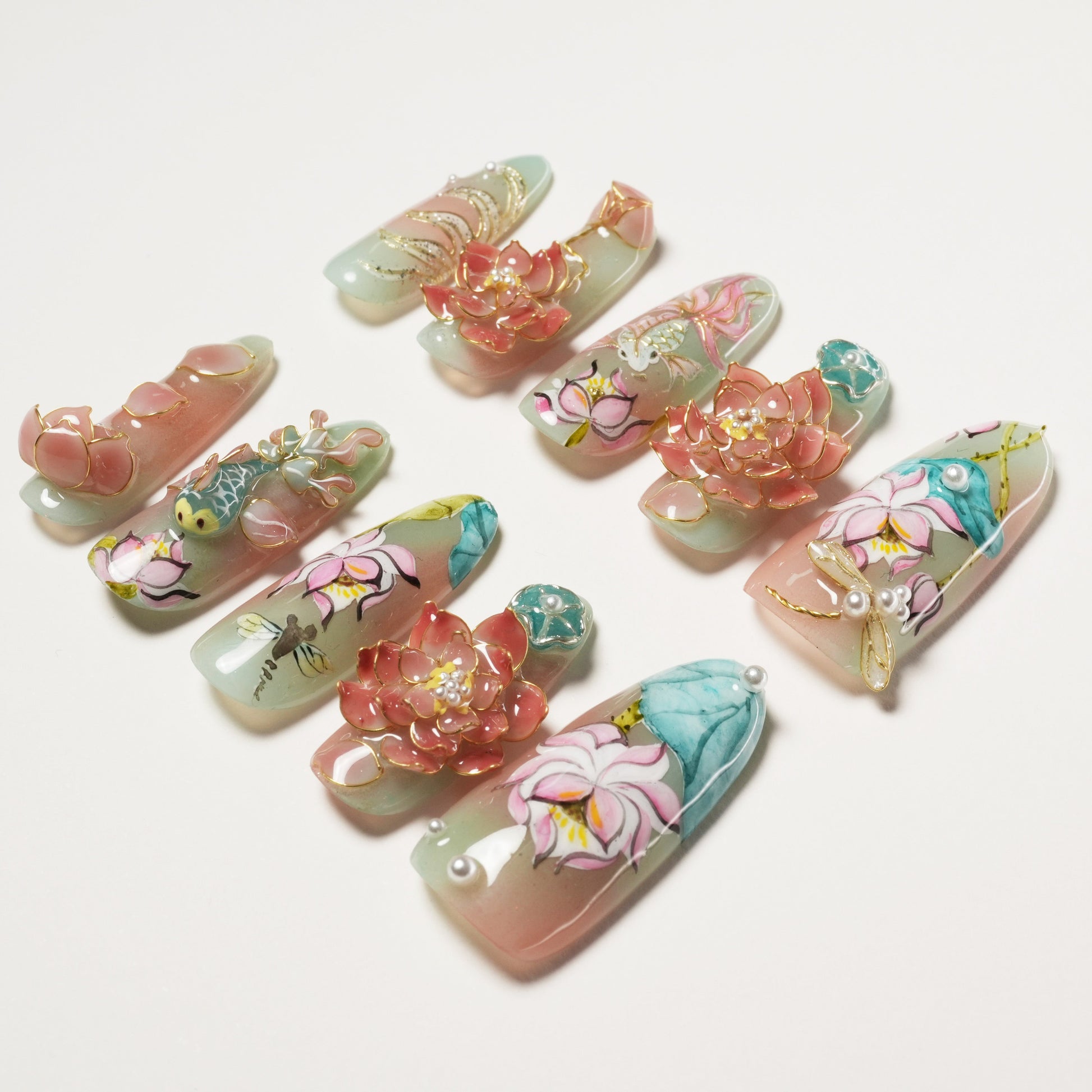 Set of intricately designed false nails with floral and bird 3D art in soft pastel colors