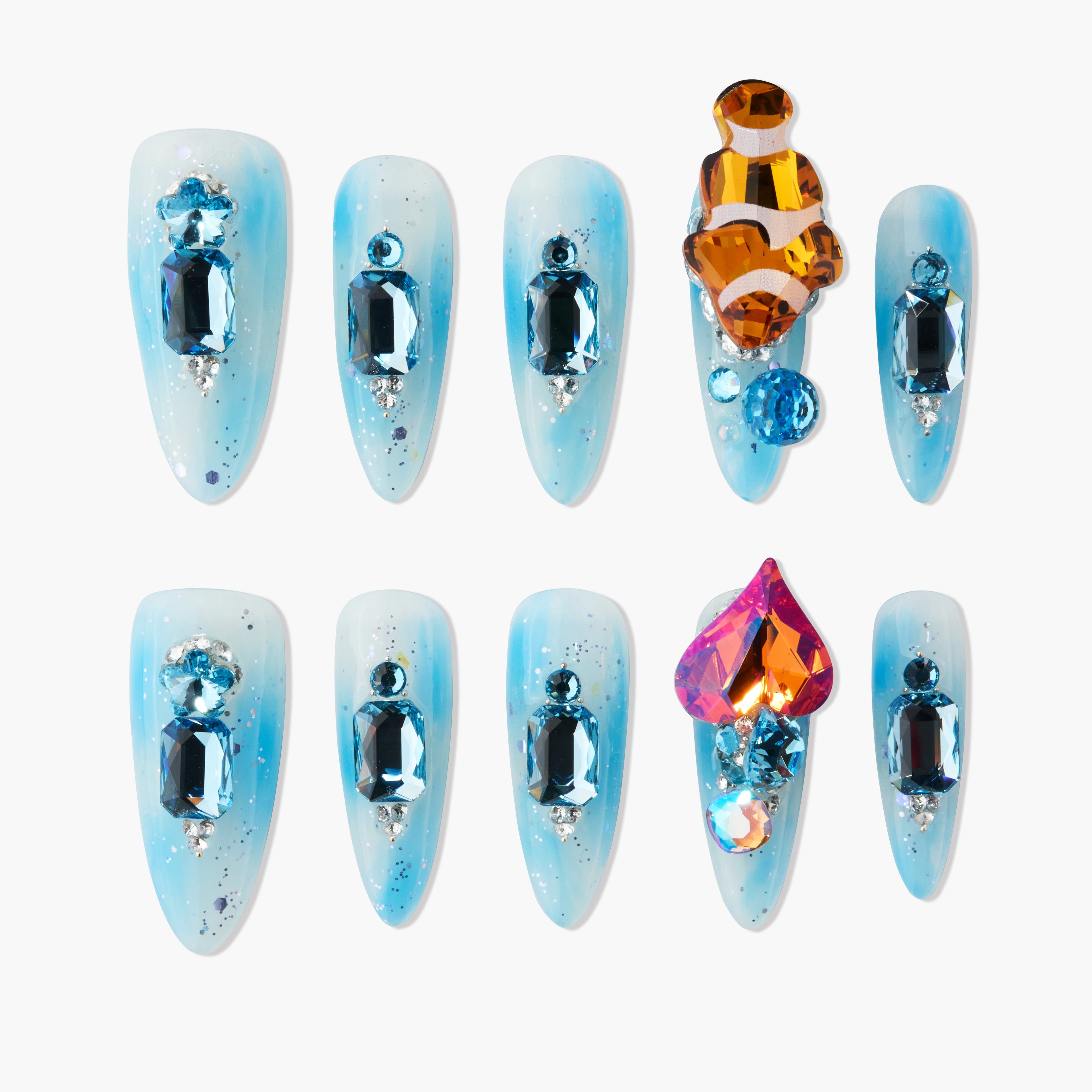 Blue ombre press-on nails with large blue and orange gemstone designs on white background