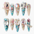 Set of ten long acrylic nails decorated with colorful crystals, gems, pearls, and glitter in pink, blue, and nude tones