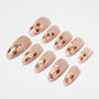 Almond-shaped nude press-on nails with red strawberry and white floral designs