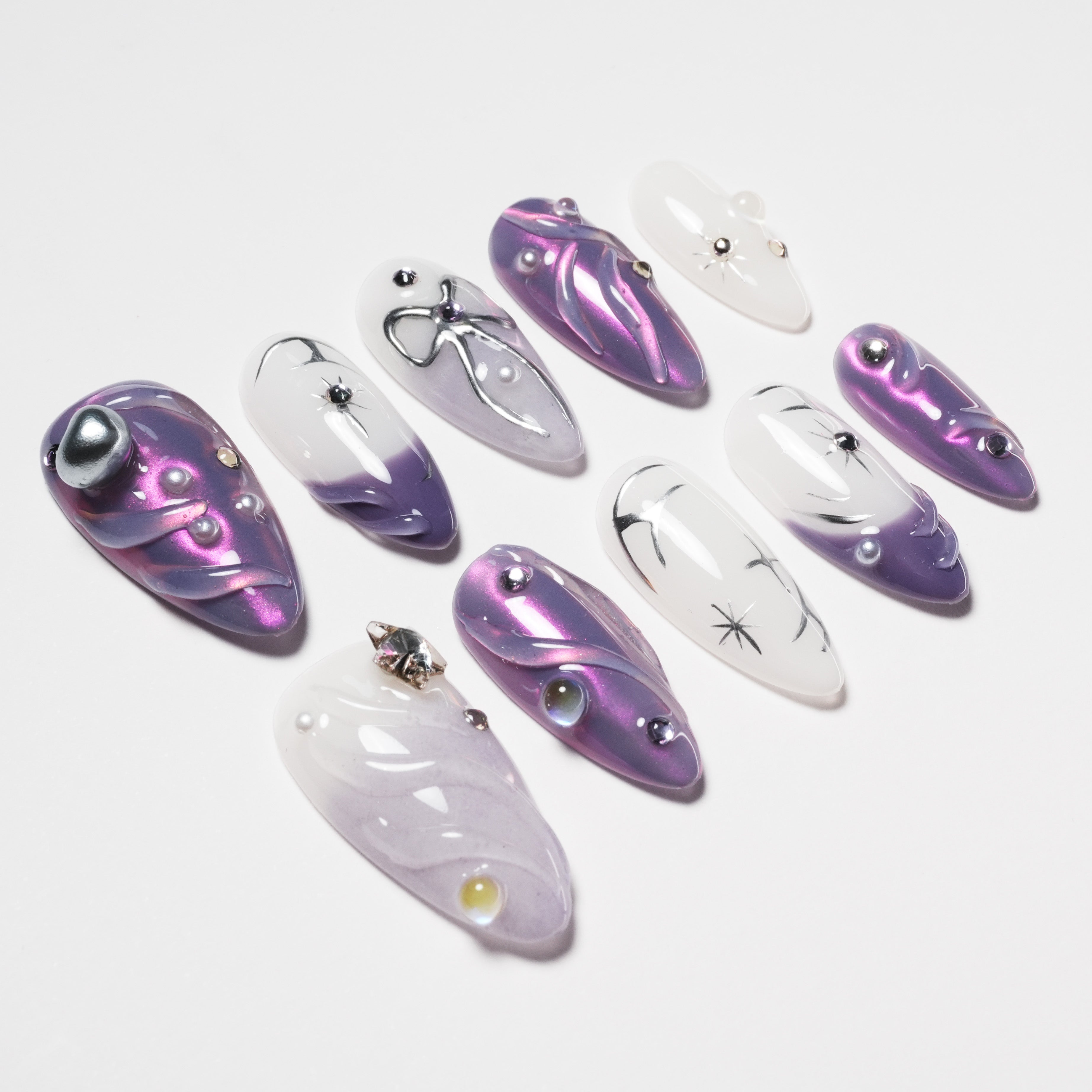 Set of purple and white gradient press-on nails with 3D silver and gem embellishments on white background