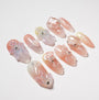 Handmade press-on nails with pink ombre, 3D floral designs, and crystal embellishments