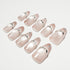Set of nude pink press-on nails with rhinestone and crystal embellishments on white background
