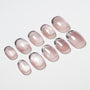Set of glittery pink press-on nails with a glossy finish on a white background