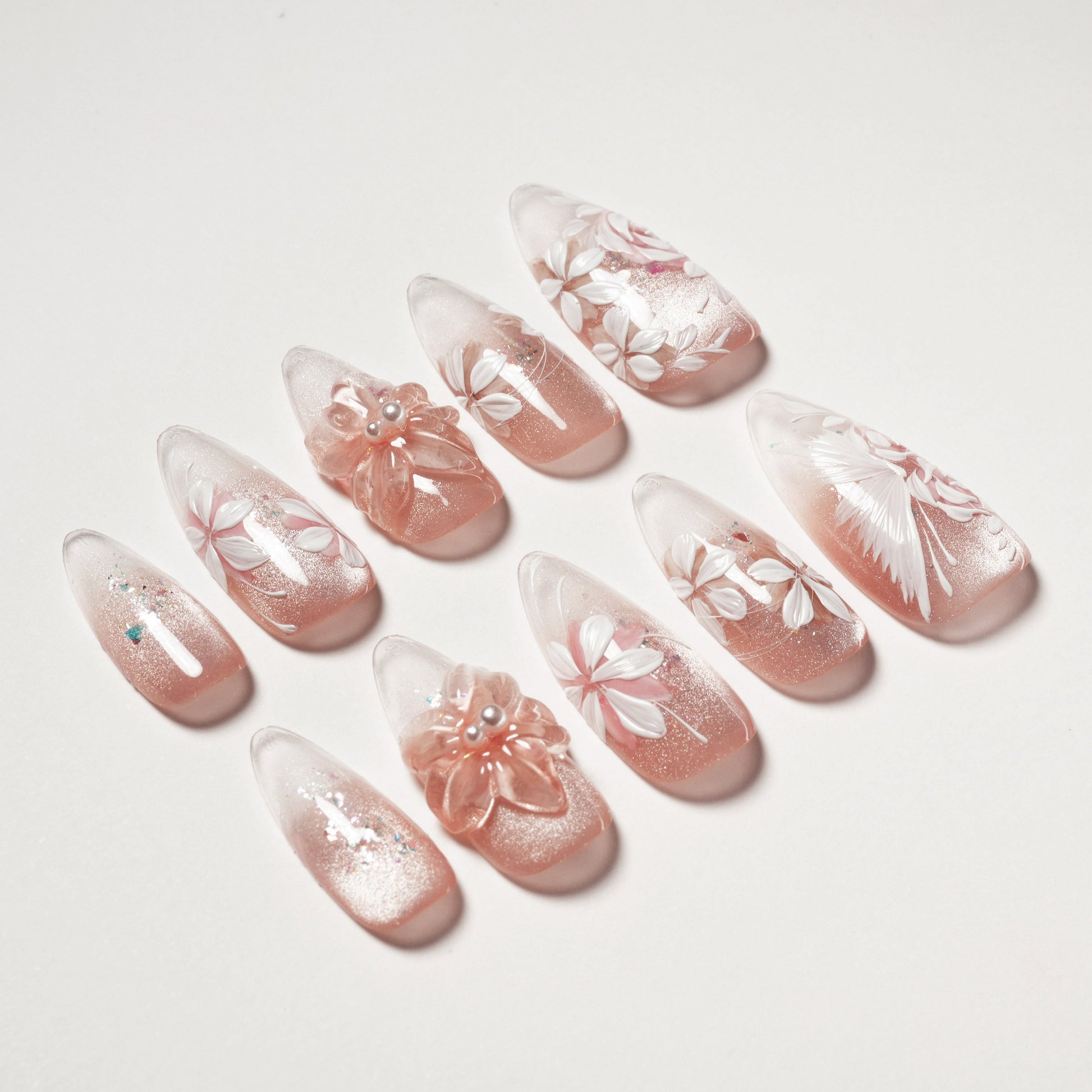 Handmade press-on nails with pink glitter base, white floral and 3D flower designs