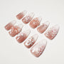 Handmade press-on nails with nude base, floral 3D designs, glitter, and pearl accents