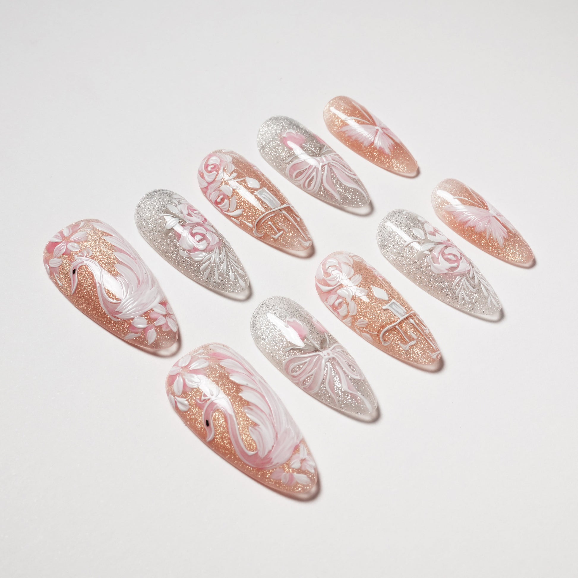 Pink and silver handmade press-on nails with glitter, swan, floral and butterfly designs