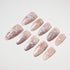 Set of nude pink false nails with delicate white floral and butterfly nail art designs