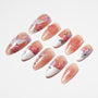 Handmade press-on nails with pink and white floral designs, butterfly and glitter accents