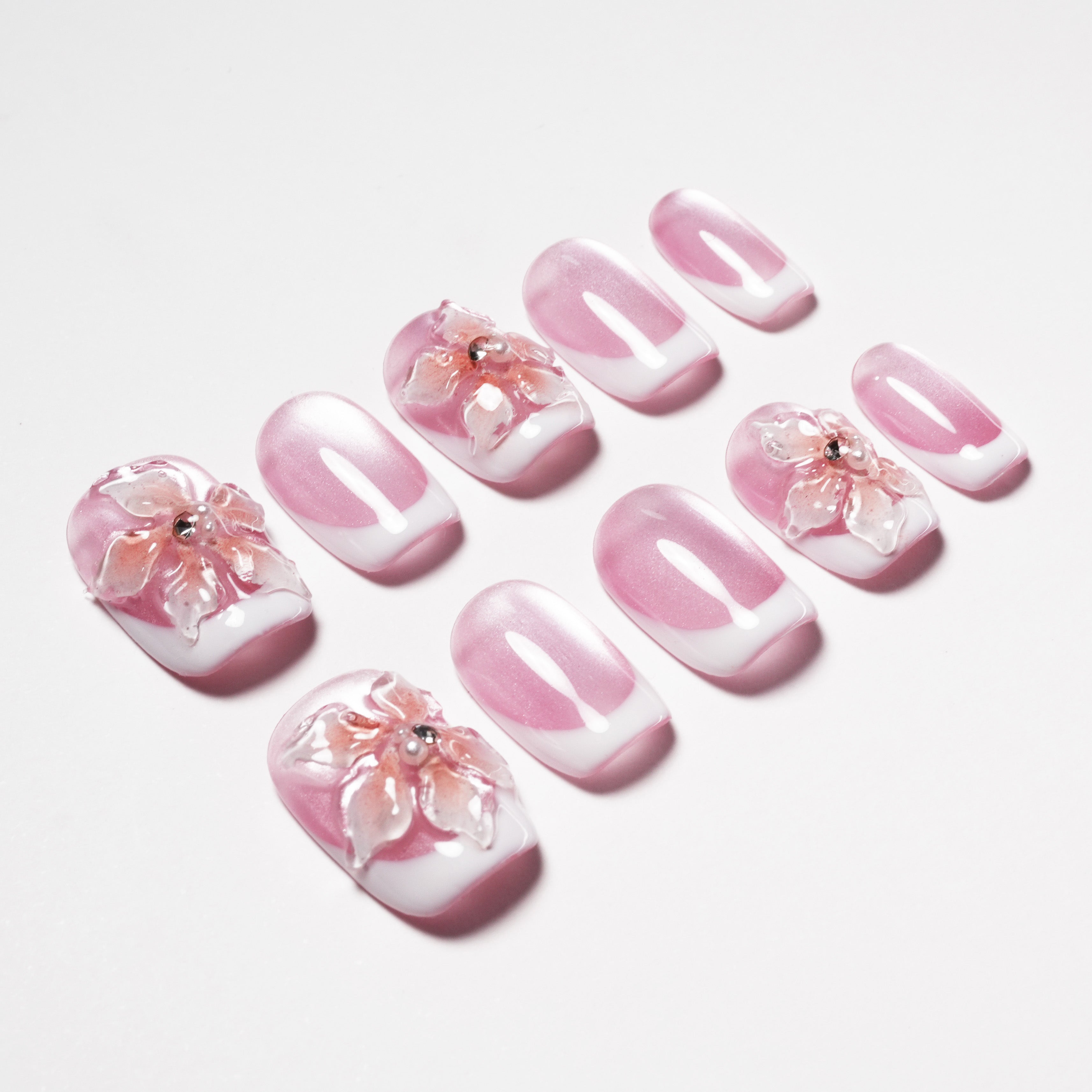 Set of pink French manicure press-on nails with 3D floral accents and rhinestones