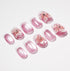 Set of glossy pink press-on nails with white tips and 3D floral decorations on a white background