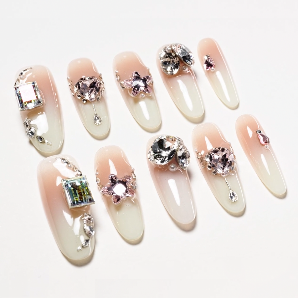 Elegant nude ombre press-on nails with large rhinestones and 3D floral and star embellishments
