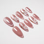 Glossy pink press-on nails with white 3D flower accents, almond shape, on white background.