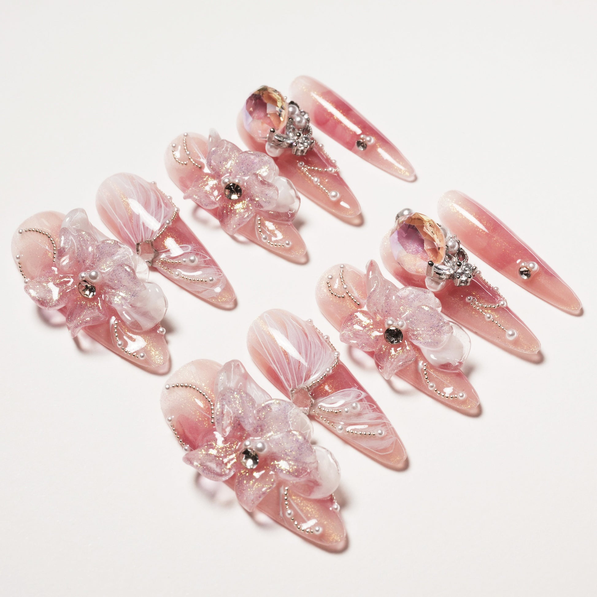 Set of elegant pink stiletto false nails with 3D floral decorations and rhinestones