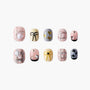 Set of decorative artificial nails with heart, bow, pink and gold designs on white background