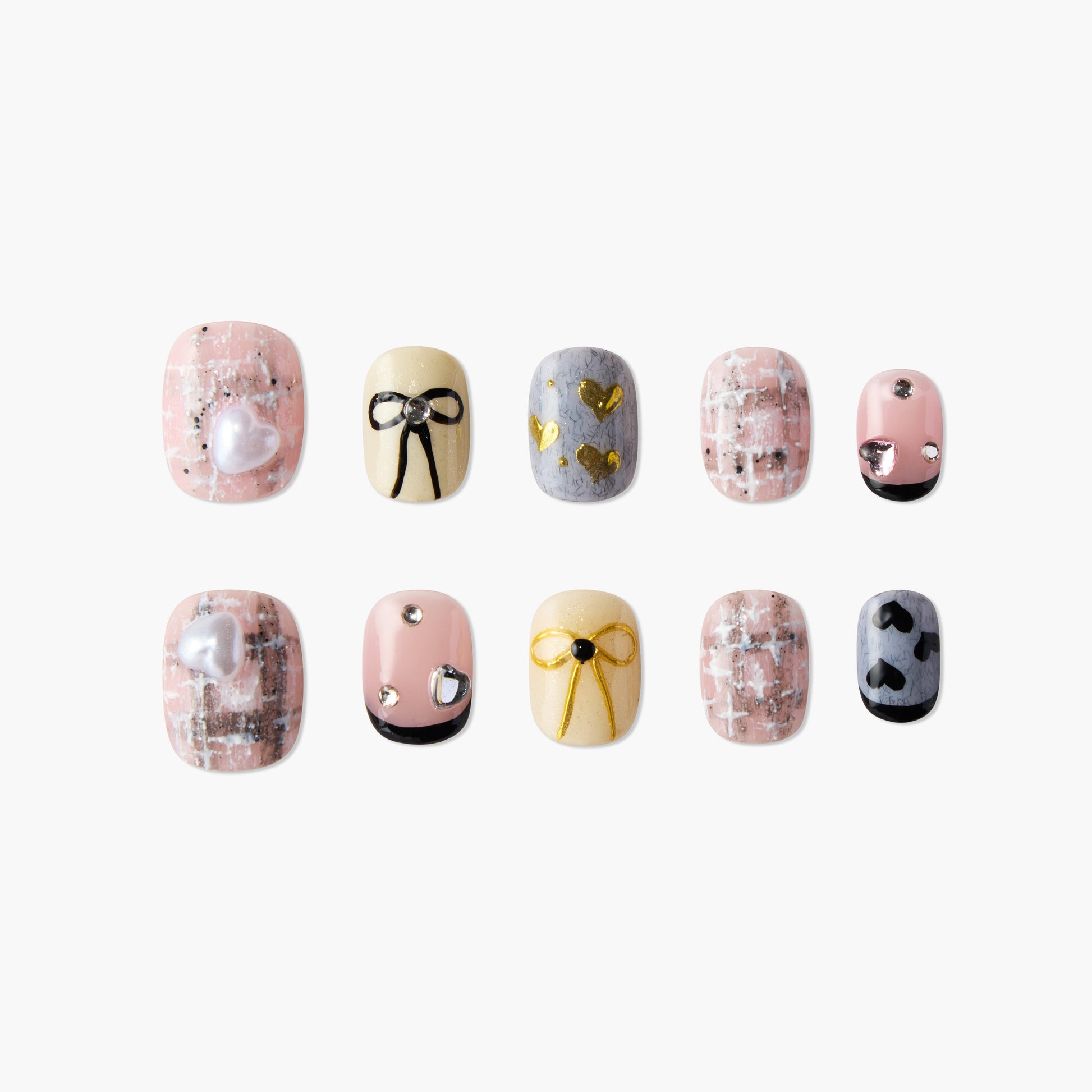 Set of decorative artificial nails with heart, bow, pink and gold designs on white background
