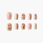 Handmade press-on nails with pink butterfly and floral designs, glitter accents, nude tones
