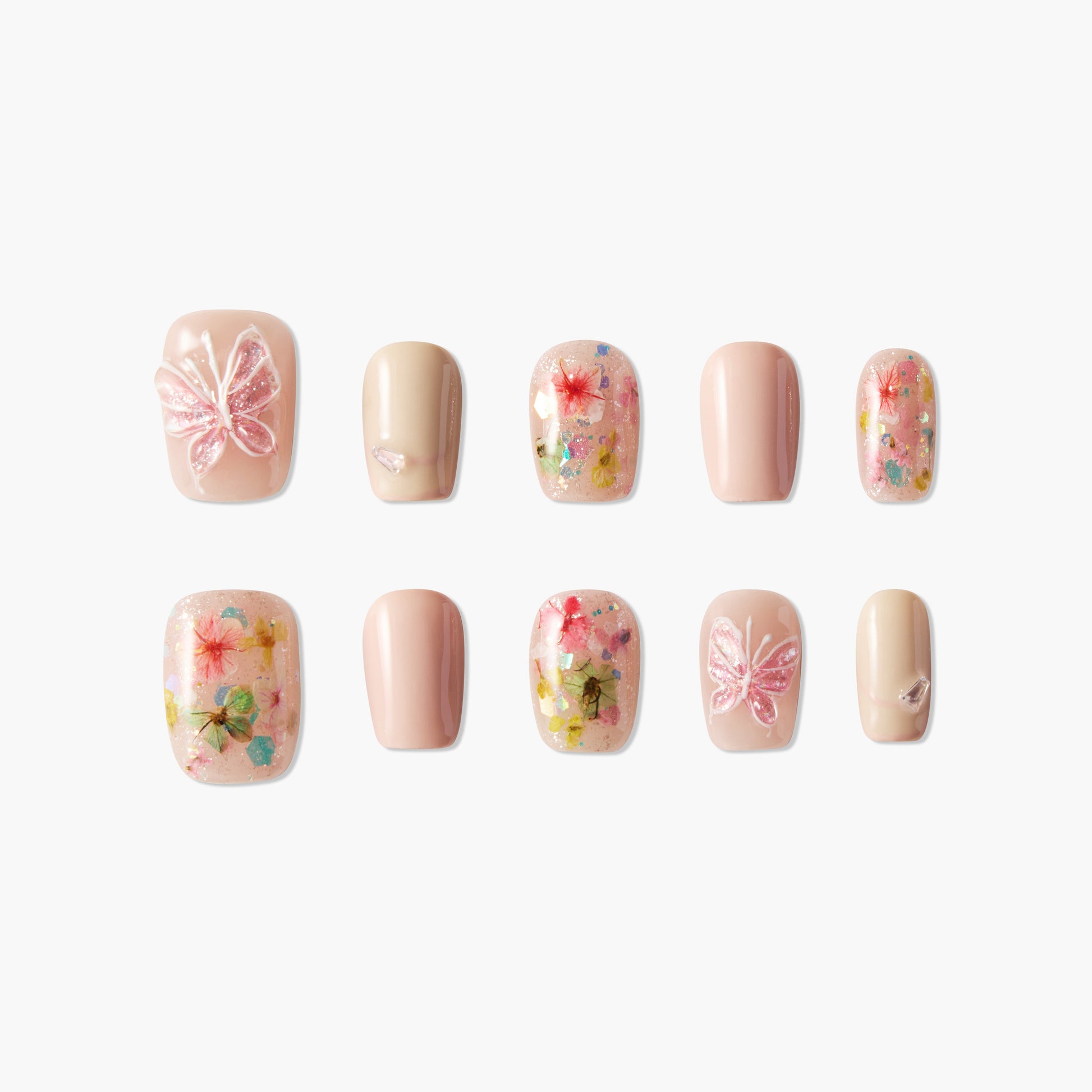 Handmade press-on nails with pink butterfly and floral designs, glitter accents, nude tones