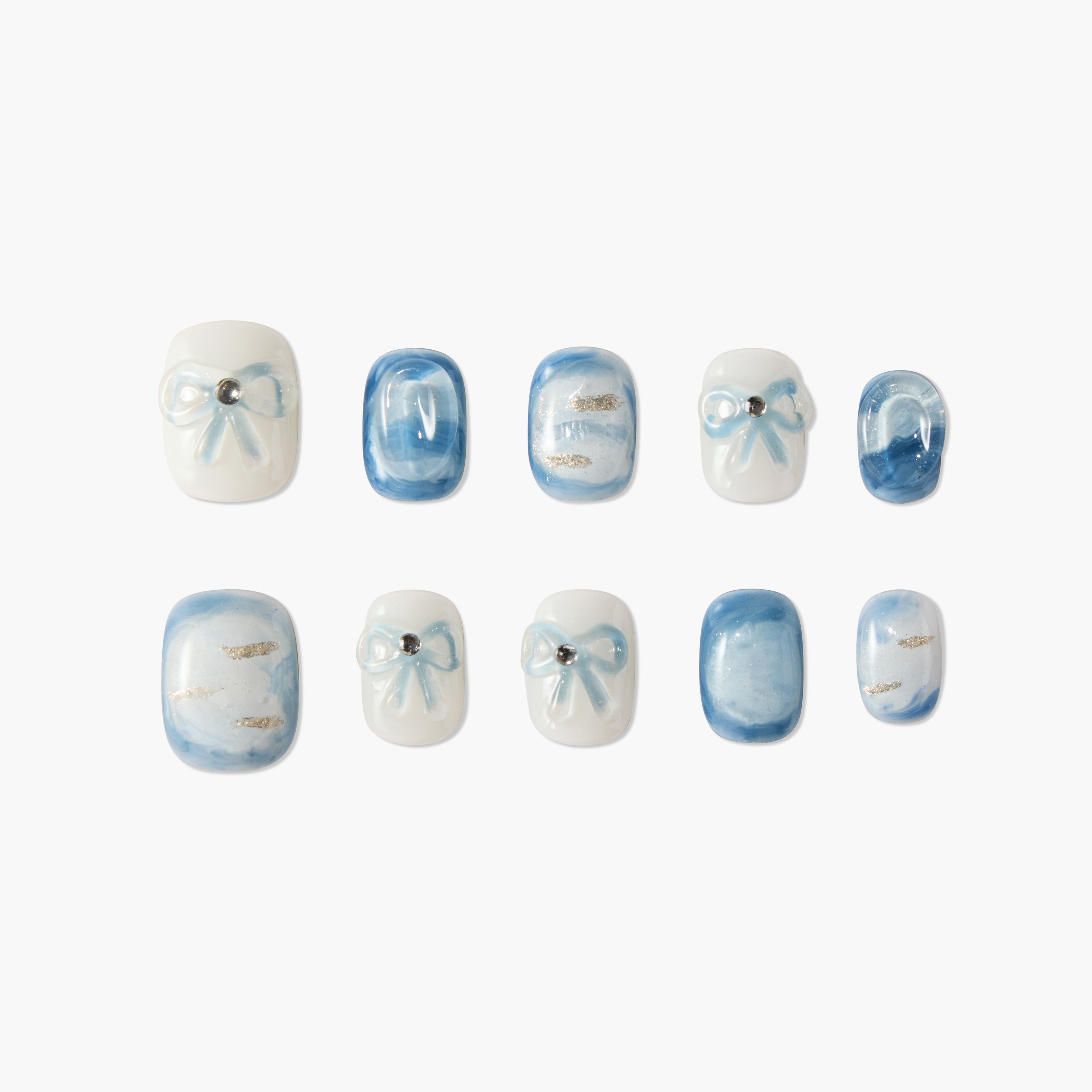 Set of blue and white marble-effect press-on nails with bow designs and rhinestone accents