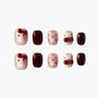 Handmade press-on nails with maroon, polka dot, and cat face designs, glossy finish.