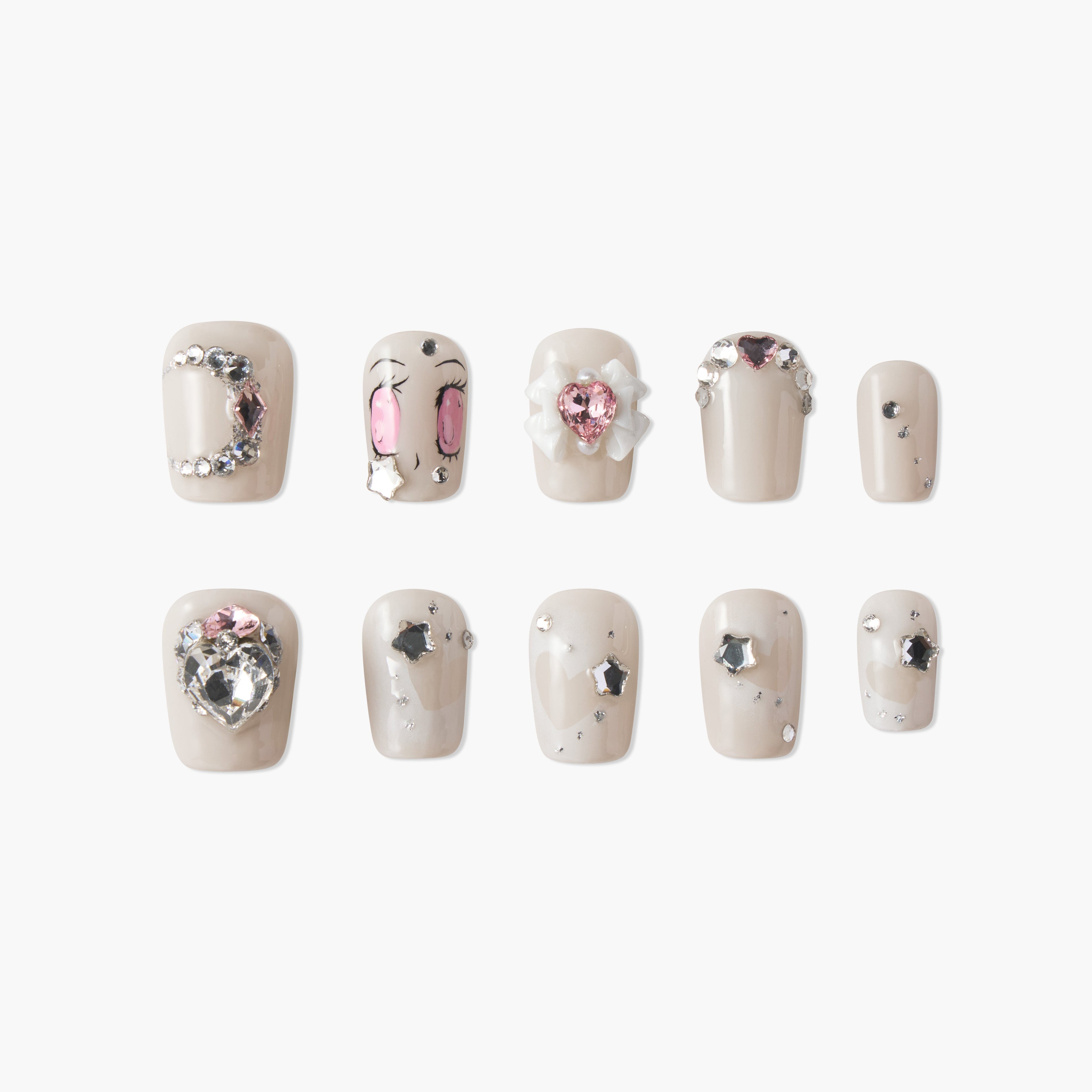 Set of beige press-on nails with pink and silver rhinestones, heart shapes, and cartoon eye designs