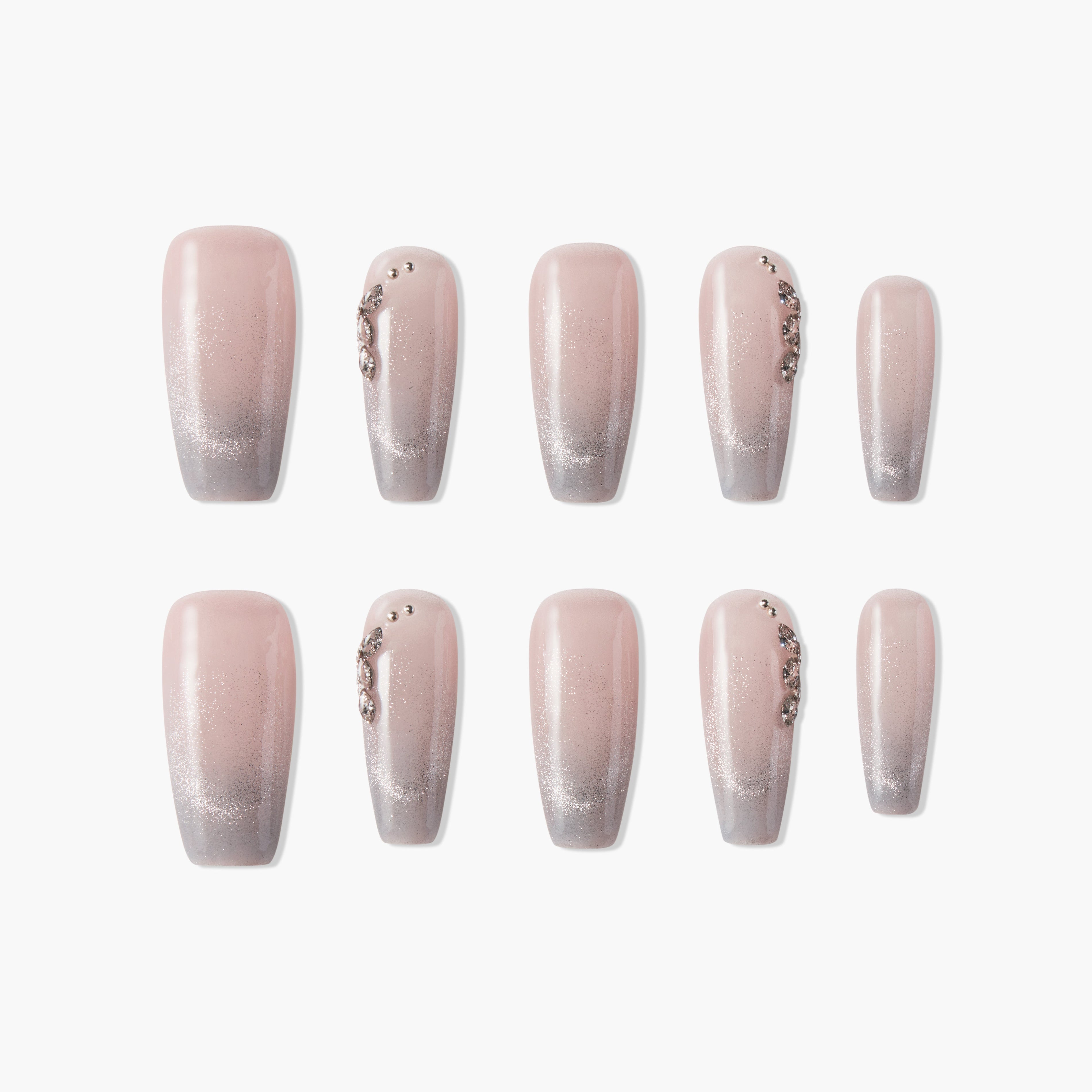 Set of elegant pink and silver ombre press-on nails with rhinestone accents on white background