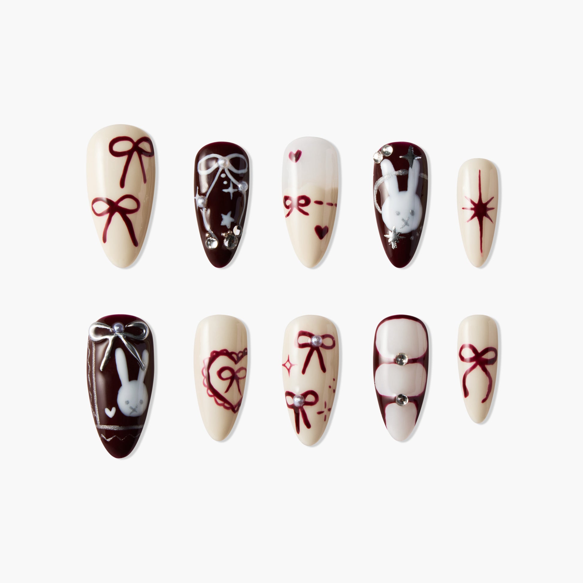 Handmade press-on nails with maroon bows, bunny art, hearts, and jewel accents on cream base