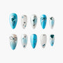 Blue and silver press-on nails with hearts, bows, rhinestones, and star accents in assorted designs
