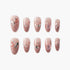 Set of pink glittery press-on nails with floral and star embellishments and rhinestones