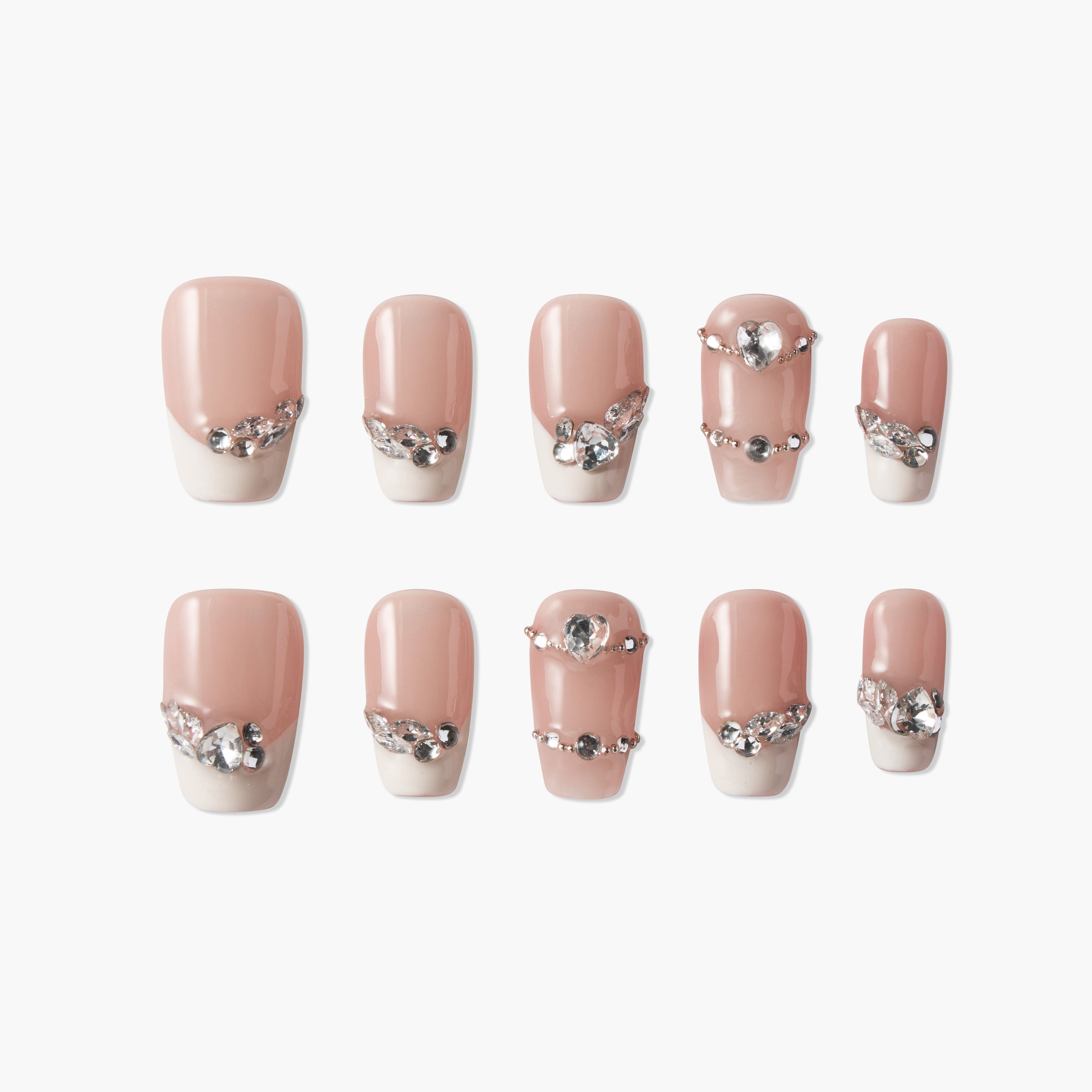 Set of nude pink and white artificial nails with rhinestone and heart-shaped gem embellishments