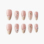 Set of pink and beige press-on nails with pearl, rhinestone, and bow nail art designs