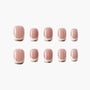 Set of pink press-on nails with gold and white French tip design on white background