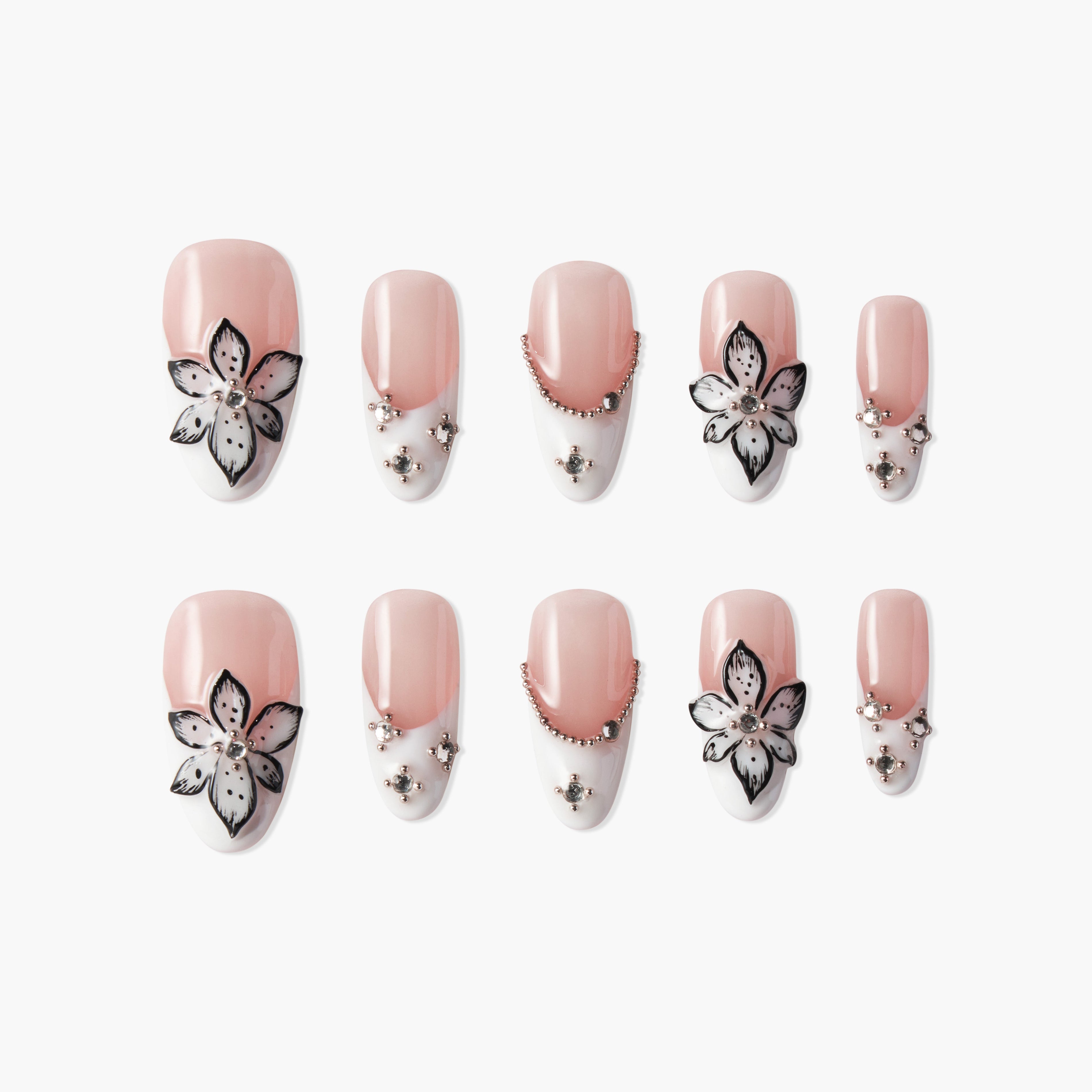 Set of 10 artificial nails with pink and white gradient, black and white flower art, and small silver studs