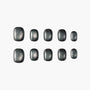 Set of matte black press-on nails with silver shimmer, arranged on a white background