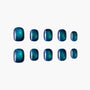 Set of glossy teal and navy ombre press-on nails with a shimmery finish on white background