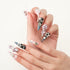 Stiletto-shaped nails with pink, black, and silver polish decorated with pearls, rhinestones, and heart gems