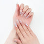Hand with iridescent, pearl-embellished press-on nails in a stylish manicure design