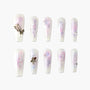 Handmade press-on nails with pastel floral designs, butterfly charms, and pearl accents