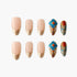 Set of elegant press-on nails with nude and gold tips, accented by blue and red gemstone designs