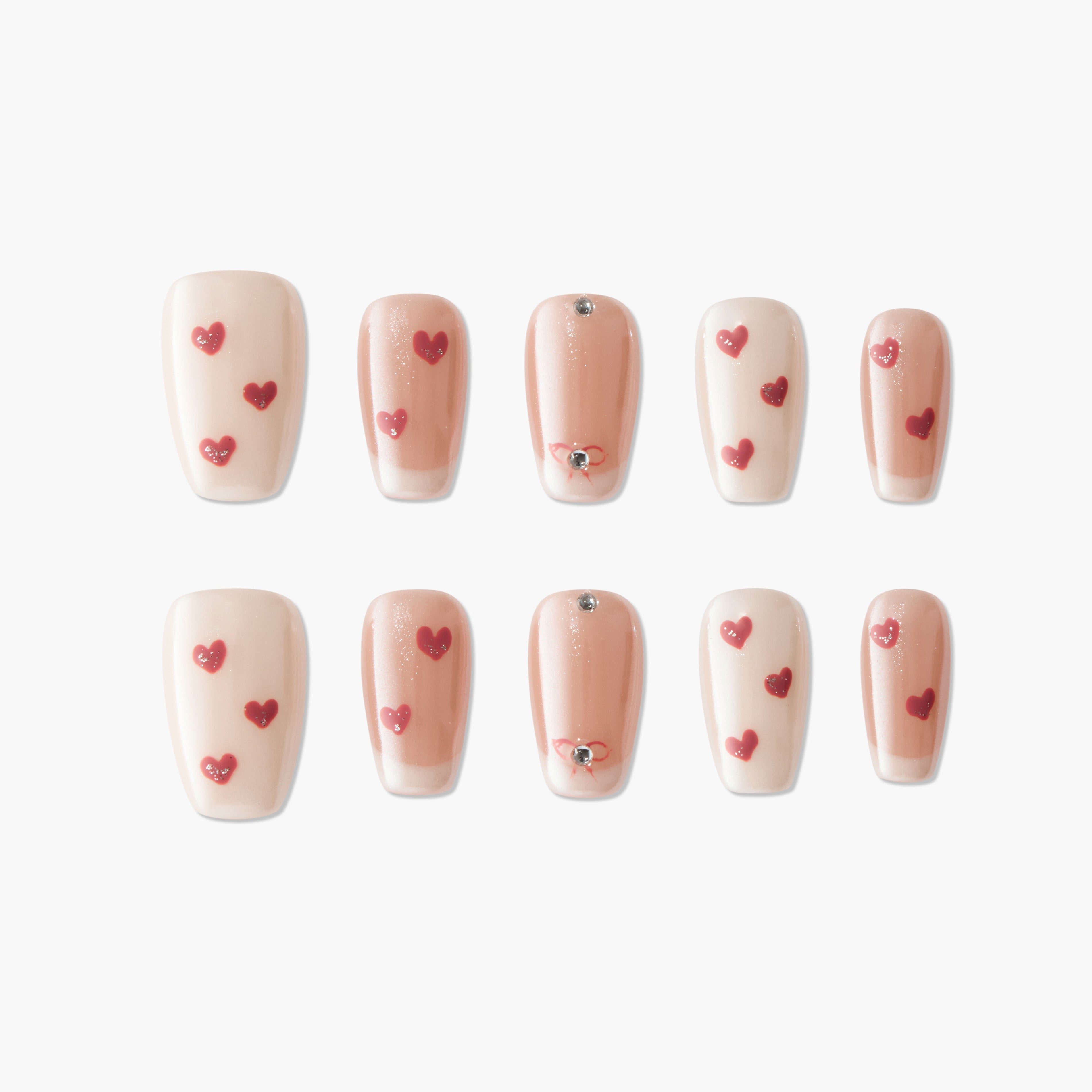 Set of beige and nude false nails decorated with red heart designs and small silver studs