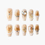Handmade press-on nails with gold glitter, 3D floral designs, pearls, and crystal gems
