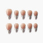 Set of ten nude and silver gradient press-on nails with rhinestone accents on white background