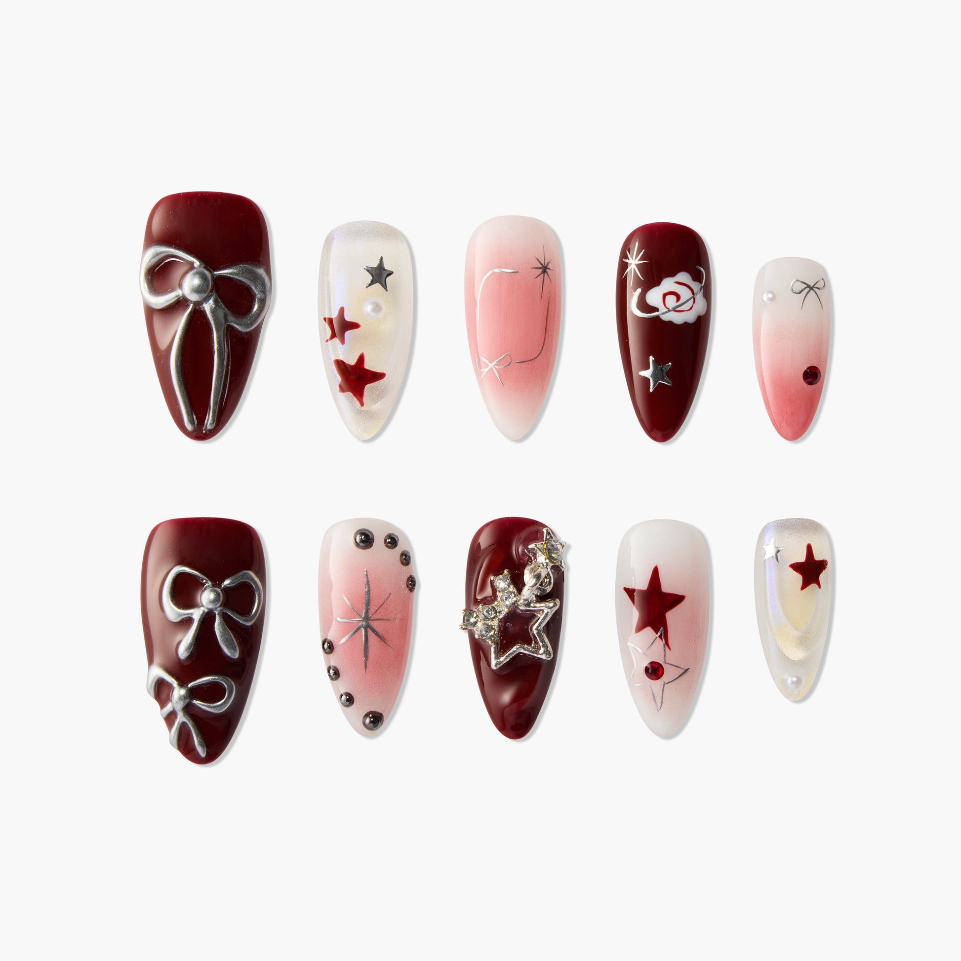 Red and pink press-on nails with star, bow, pearl, and 3D embellishments, arranged on white background