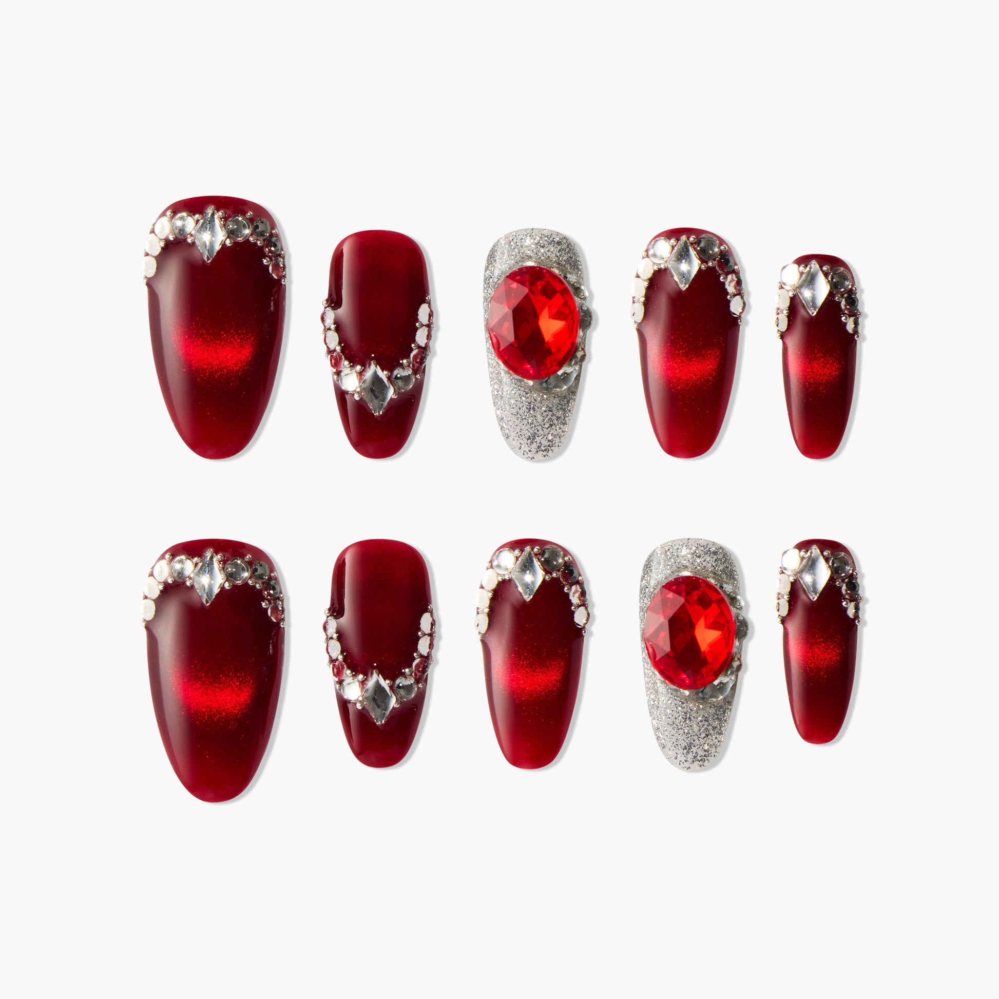 Red press-on nails set with silver rhinestones and large red gem accents on a white background.