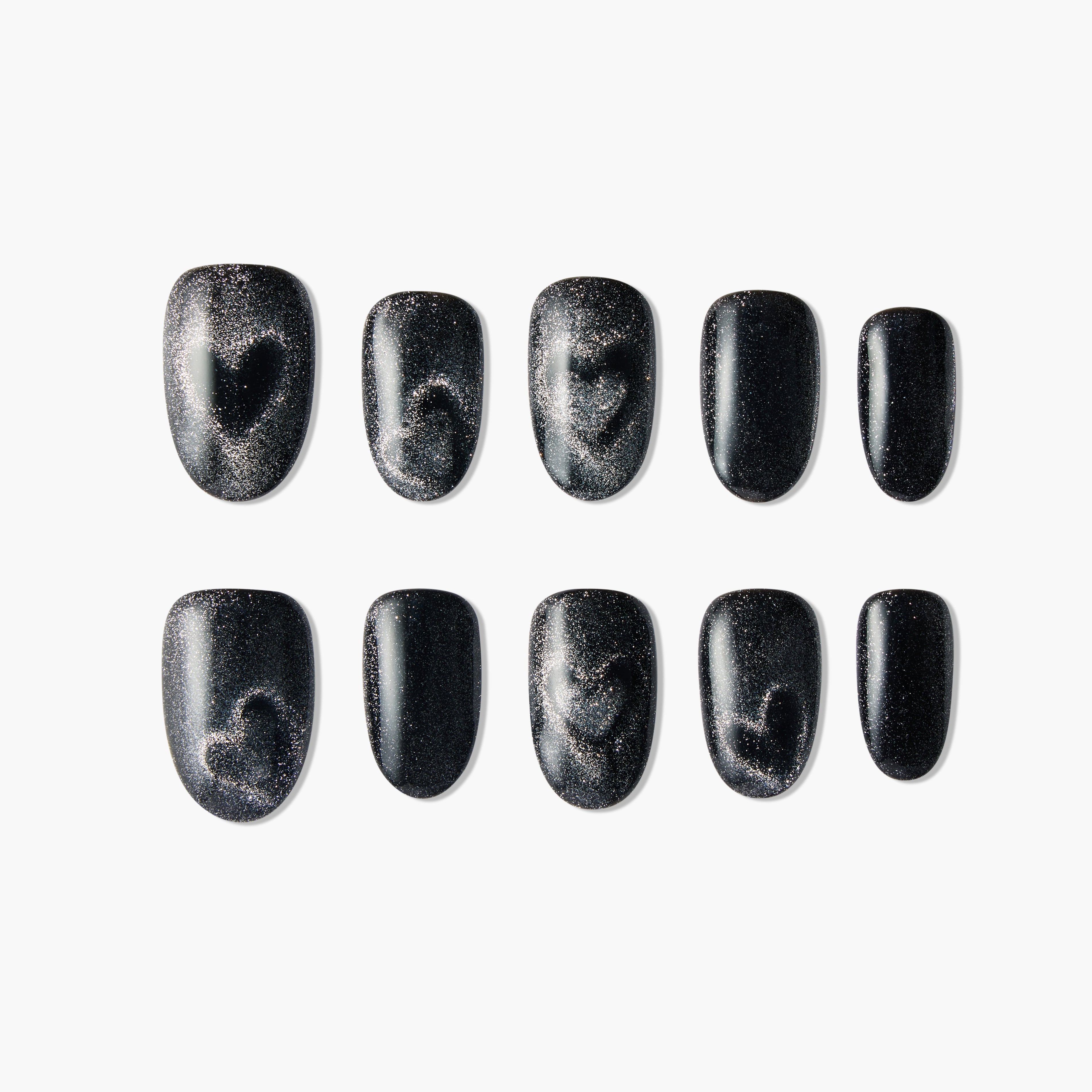 Set of black glittery fake nails with subtle heart designs on white background