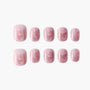 Set of pink glittery press-on nails with subtle butterfly designs, arranged on white background