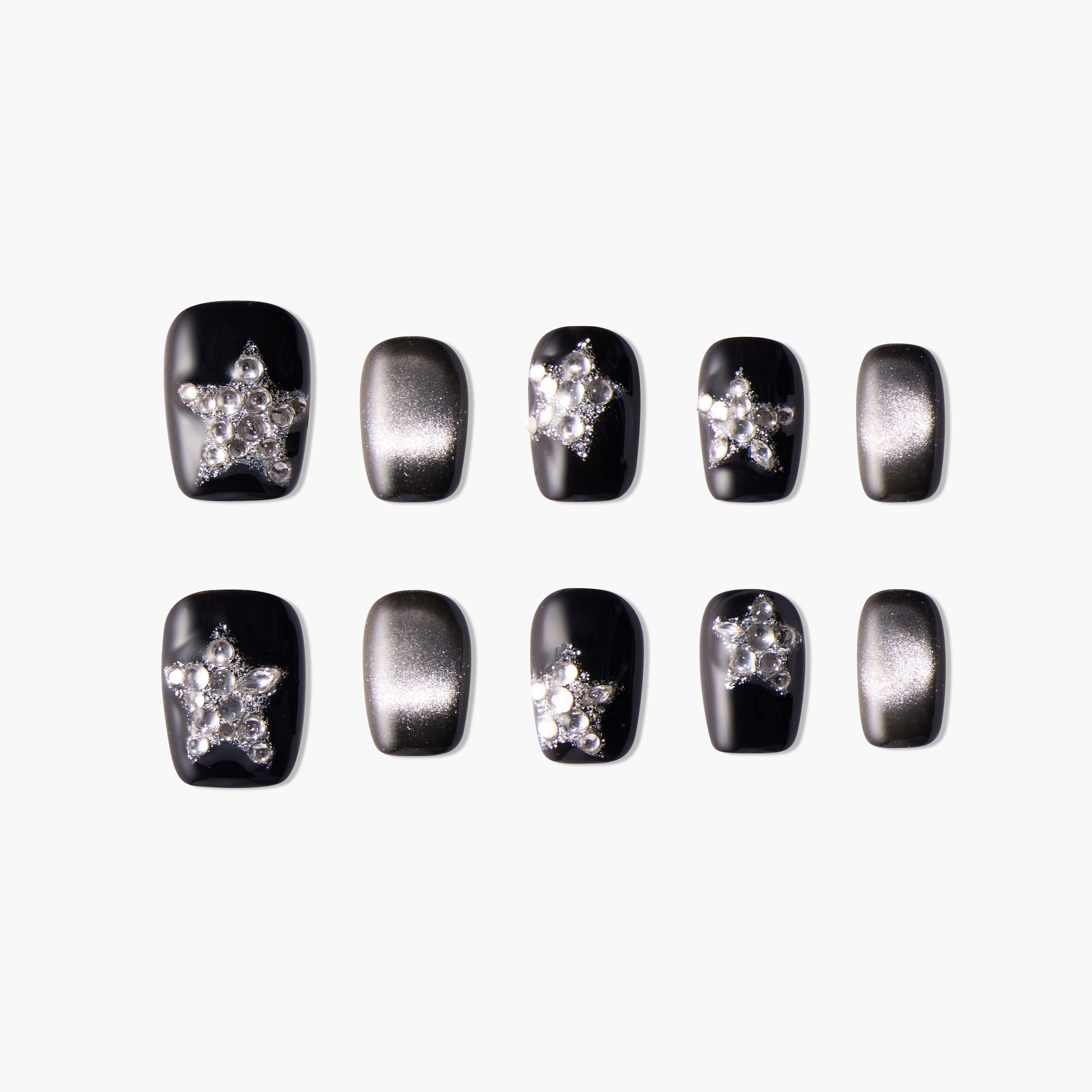 Set of black and silver false nails with rhinestone star designs on a white background