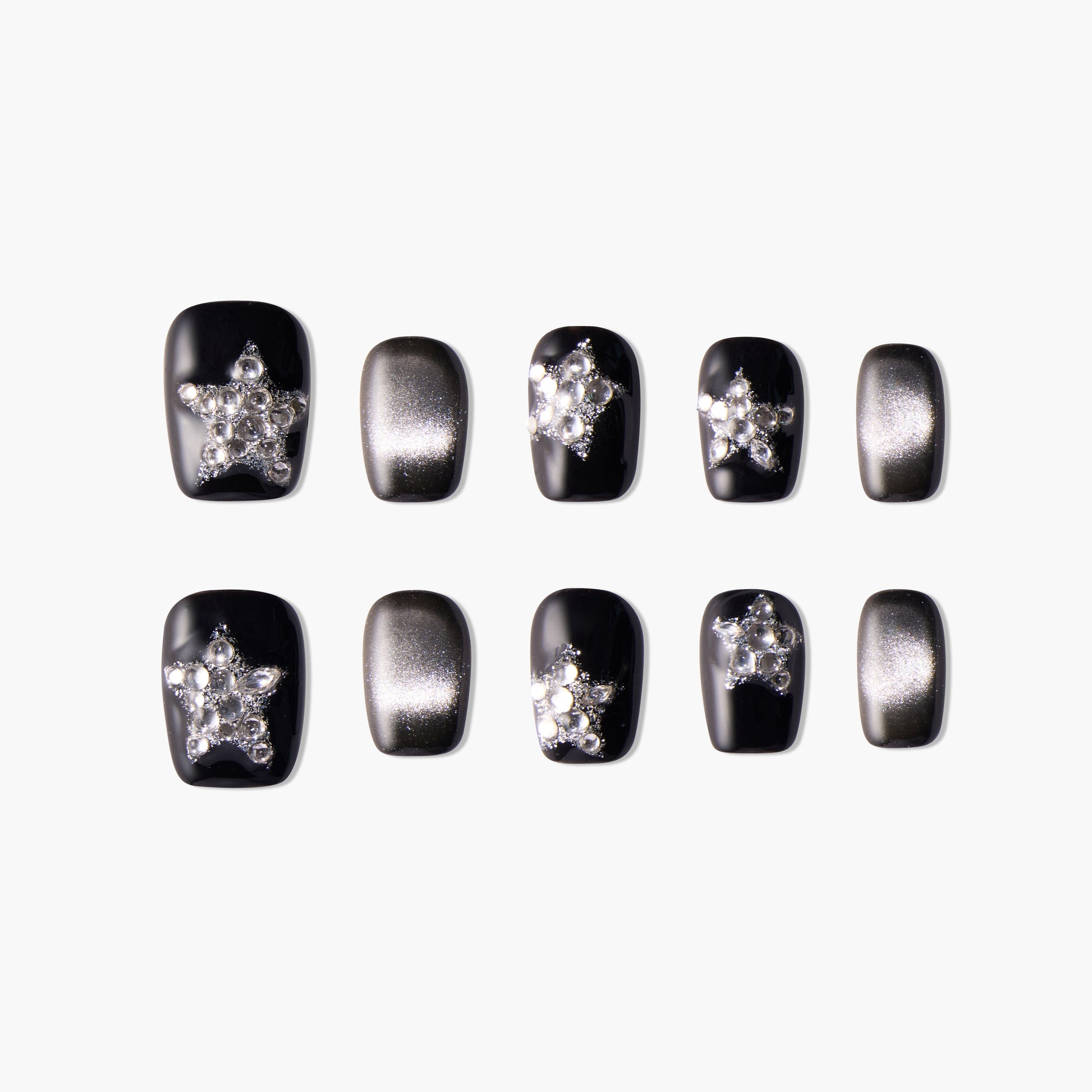 Black and silver press-on nails with star-shaped rhinestone accents, glossy finish